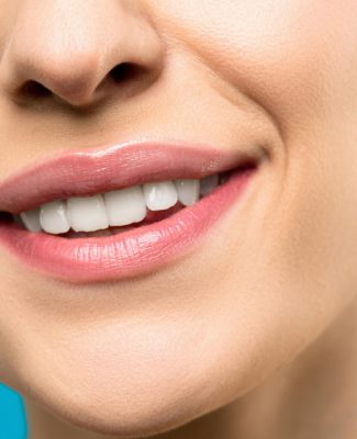 A close-up image of a woman's smile with pink lipstick and white teeth against a blue background.