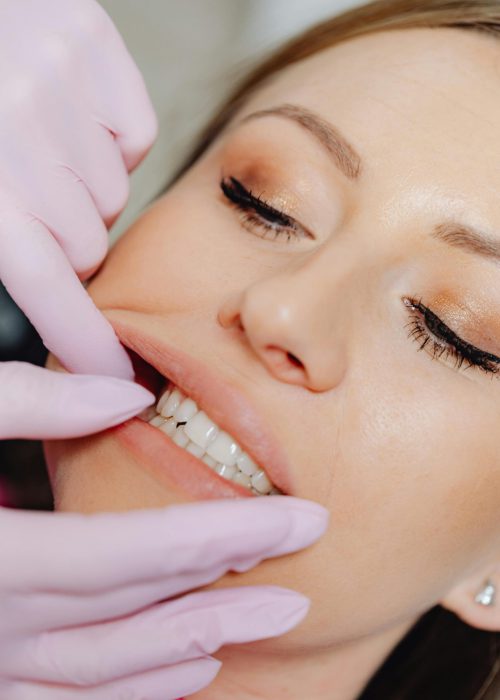 Detailed close-up of a dental examination showing a woman's teeth with latex gloves.
